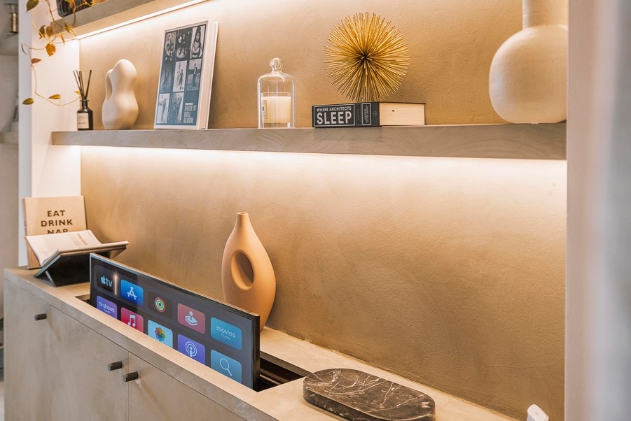 A hidden TV rises from a custom cabinet in a room.