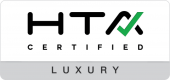 Rectangular “HTA Certified Luxury” logo with black letters, a green check mark integrated into the letter A, and a gray bar along the bottom with the word “Luxury.”